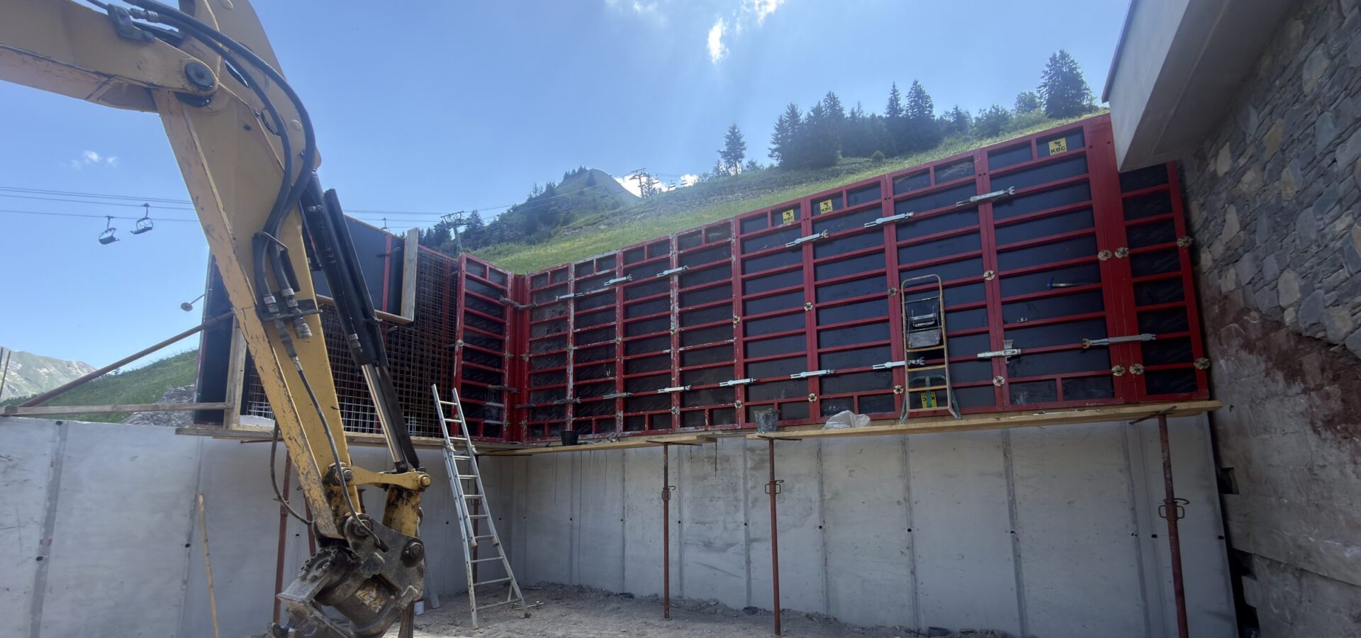 Coffrage d'un mur de soutènement et pelle mécanique sur un chantier Gouttenoire TP/GC